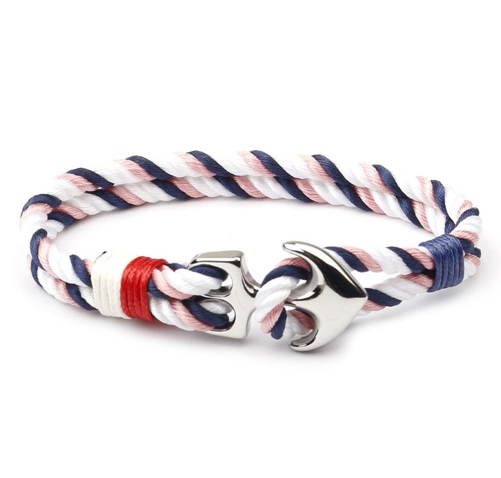 Anchor charm marine bracelet on weathered dock wood, showing rope texture.