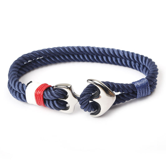 Anchor charm marine bracelet on weathered dock wood, showing rope texture.